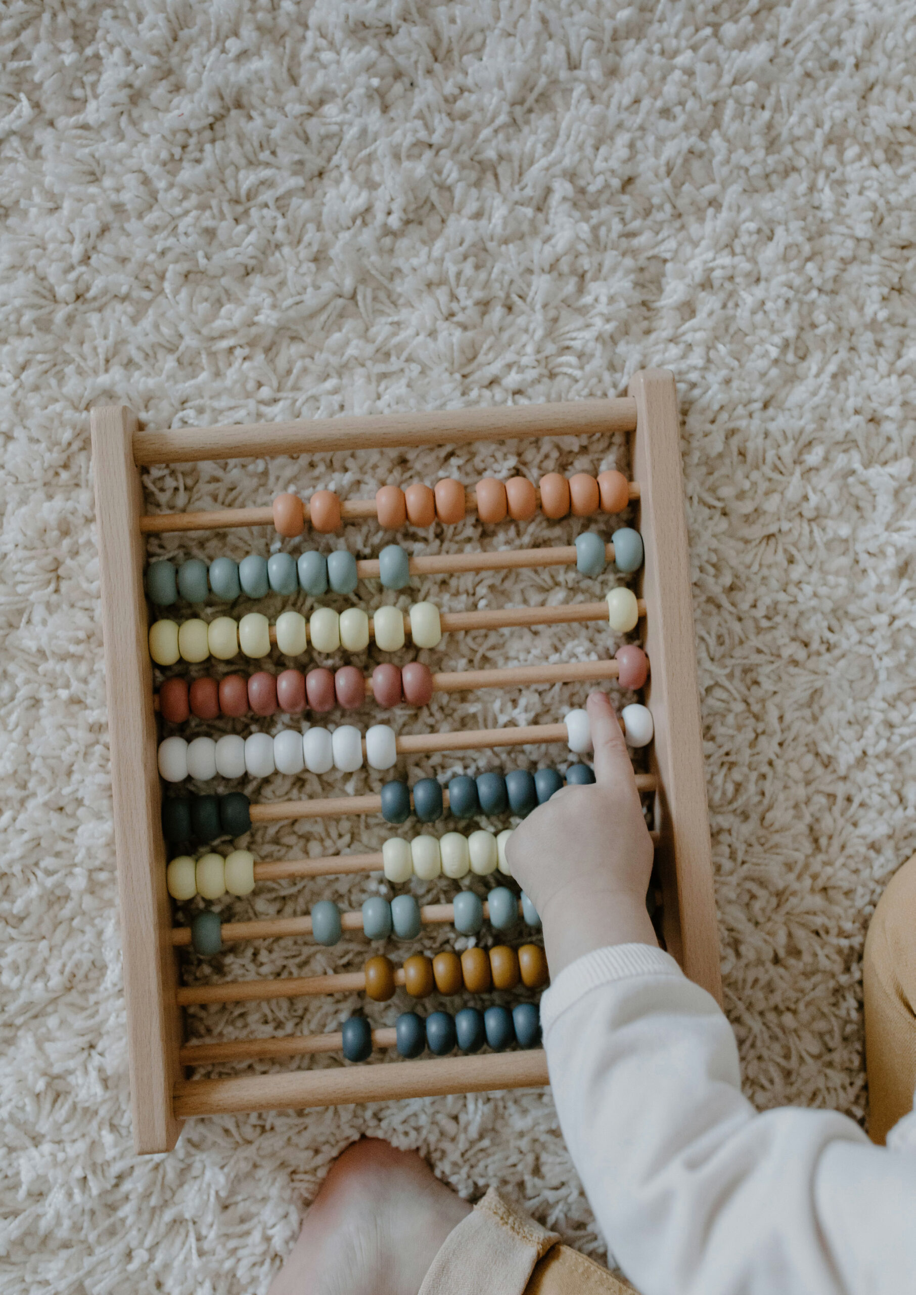 Un enfant manipule les perles d’un boulier.